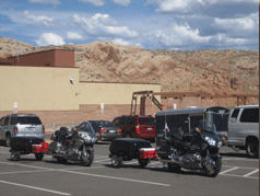 Touring motorccyles at Arches National Park visitors center towing DIY homemade motorcycle trailers.