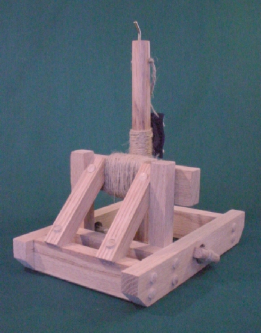 Front view of a working model onager catapult in the fired postion showing the arm  against the stop