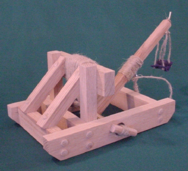 Side view of an onager catapult in the cocked postion showing the arm stop, release  pin, and sling with pouch.