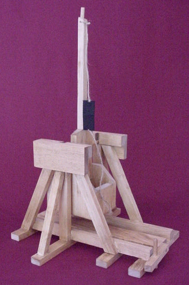 Side view of a tabletop medieval trebuchet model in the fired position
