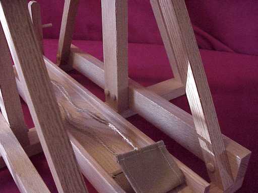 Side view of a working scale model trebuchet showing the guide and sling.