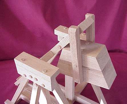 Top view of a working scale model trebuchet showing the hinged counterweight and pillow blocks.