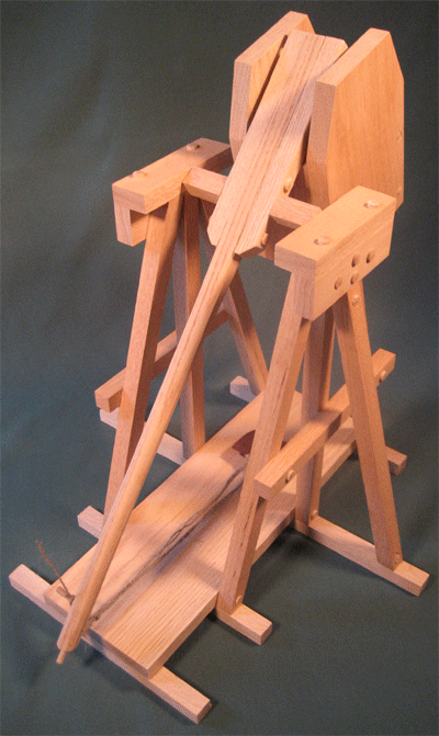 Top back view of a trebuchet in the cocked position showing the release mechanism and hinged counterweight