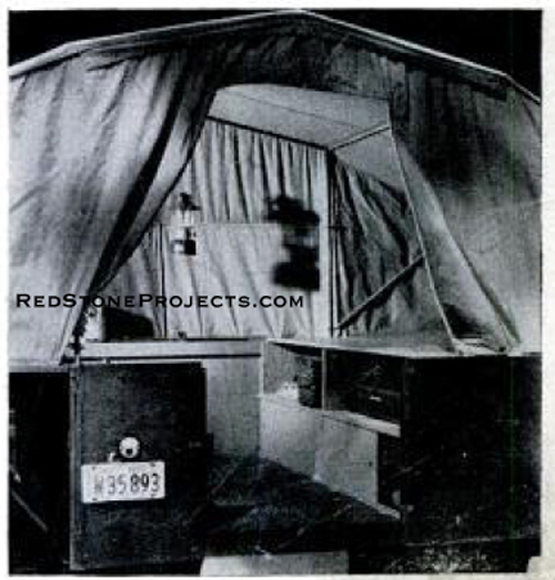 Set up tent trailer with open door and hanging lantern.
