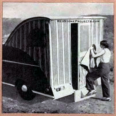 Woman installing the the rear fabric panel, with door opening on an opn Wild Goose camping trailer.