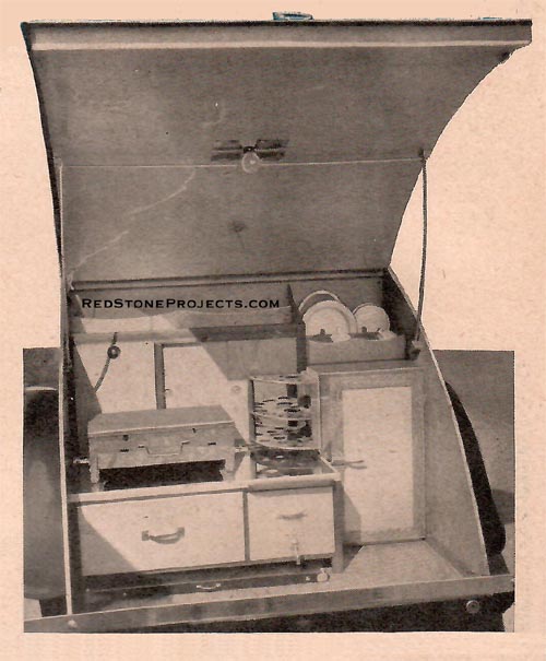 The lid raised to give access to the kitchenette. A folding table is stored beneath the drawer.