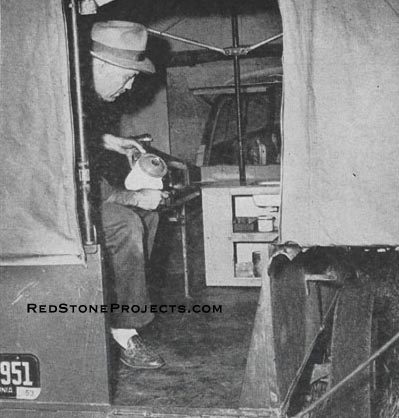 With the sleeping bag rolled off the shelf and the portable cupboard-sink in place and connected to a 25-foot hose, cooking and dishwashing are a cinch. Note the side support brace at right hand corner of door opening and the 28-in x 30-in screened front window.