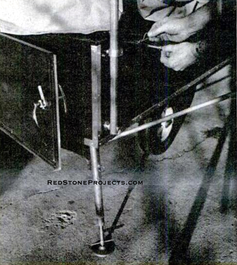 Pin support tubes into braces as you lift the top. Brackets are formed on homemade jig. Note also how jack is pinned to frame bracket when extended for stabilizing.