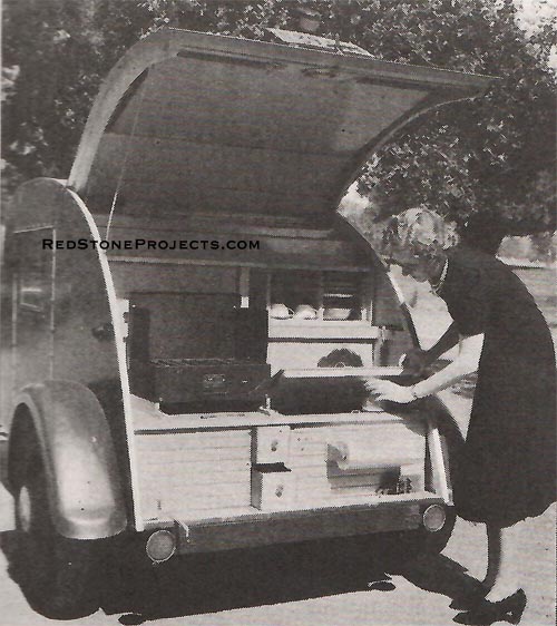 Mrs. (Lois) Roger gets a jar from the ice box. At lower left, note the water faucet made from old gas light fixture parts.