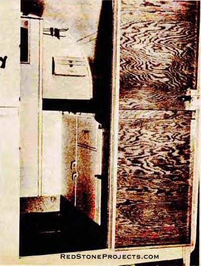 View through doors show ice box, dropped floor, cupboard detail, sink and sufficient work space.