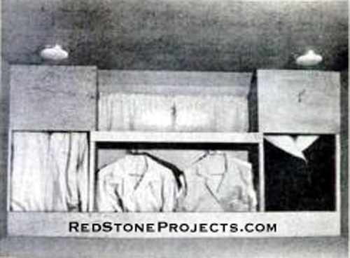 Closet For Two covers the front wall of the camper. From rods behind the top panels, there are 32 inches of hanging space. The shorter center space has rods. Drawers below the bed hold bedding and other clothing.