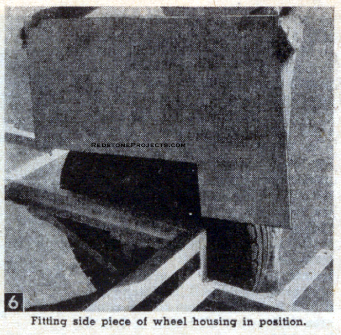 Fitting side piece of camping trailer wheel housing in position.