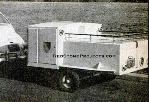 Camp kitchen trailer hitched to a vintage VW Beetle