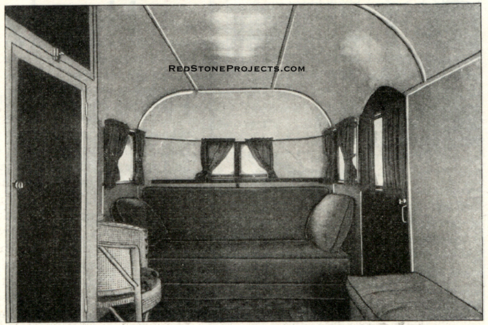 A larger view of the vintage wood framed travel trailer interior with couch.