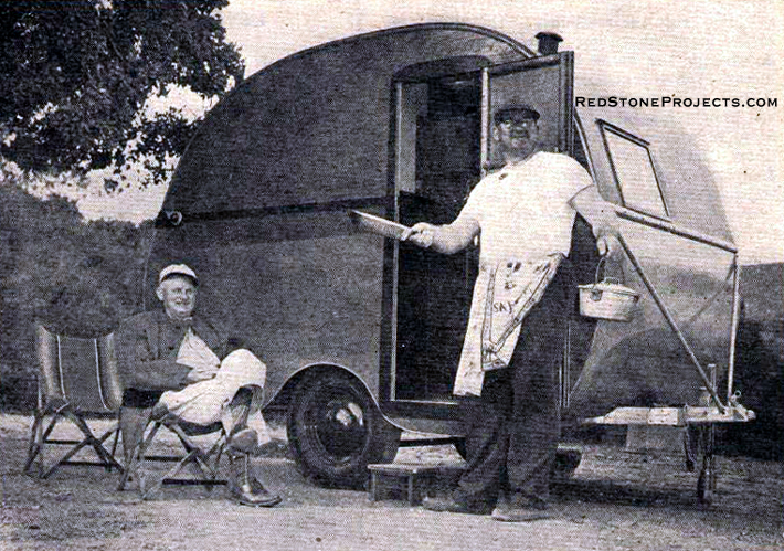 Sportsmen cooking outside a homebuilt travel trailer.